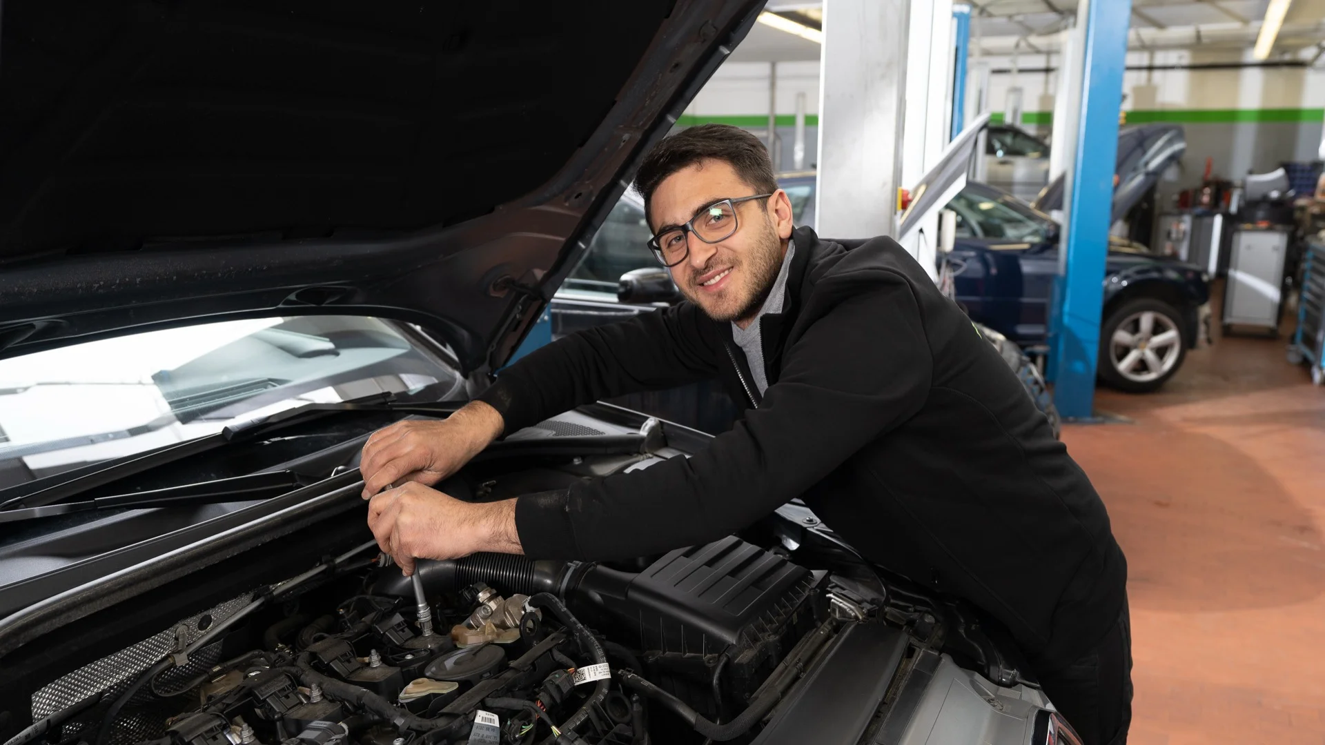 KFZ-Meister bei der Motorinspektion eines Audi in der Werkstatt München-Schwabing